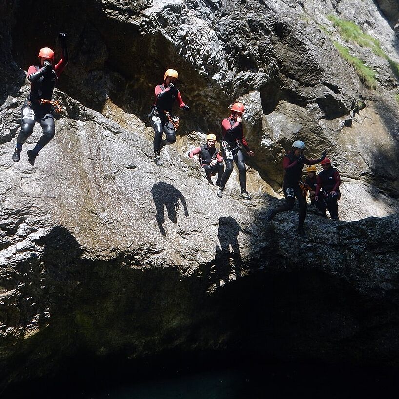 mehrere Personen gleichzeitig beim Springen ins Wasser
